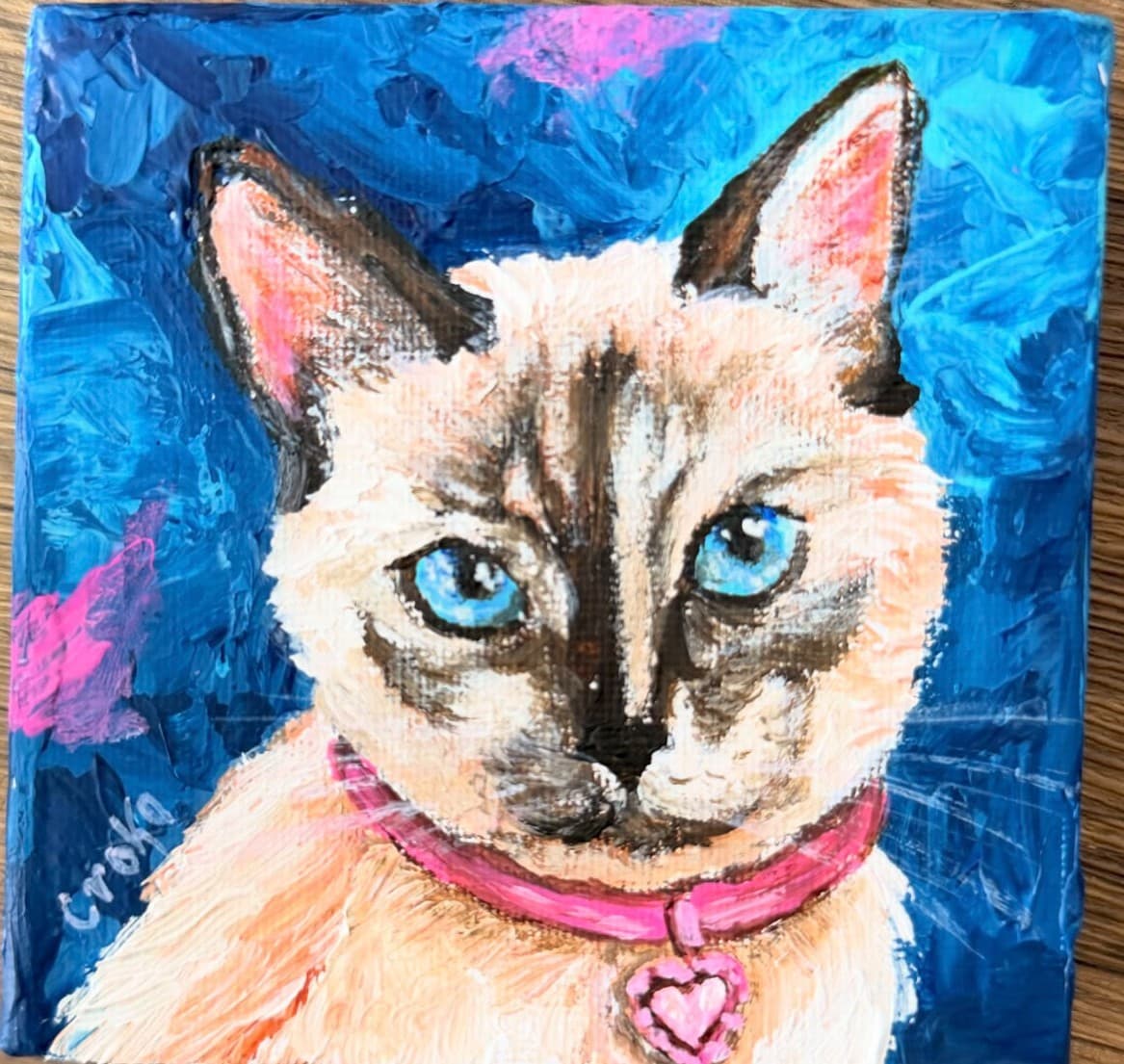 Cuadro de gato siamés de ojos azules con collar rosado, pintado a mano en impasto sobre fondo azul